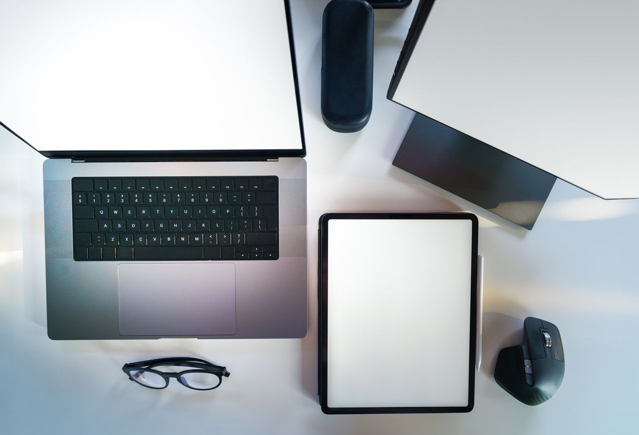 Vue de dessus d’un bureau moderne et élégant avec un ordinateur portable, une tablette et des accessoires.